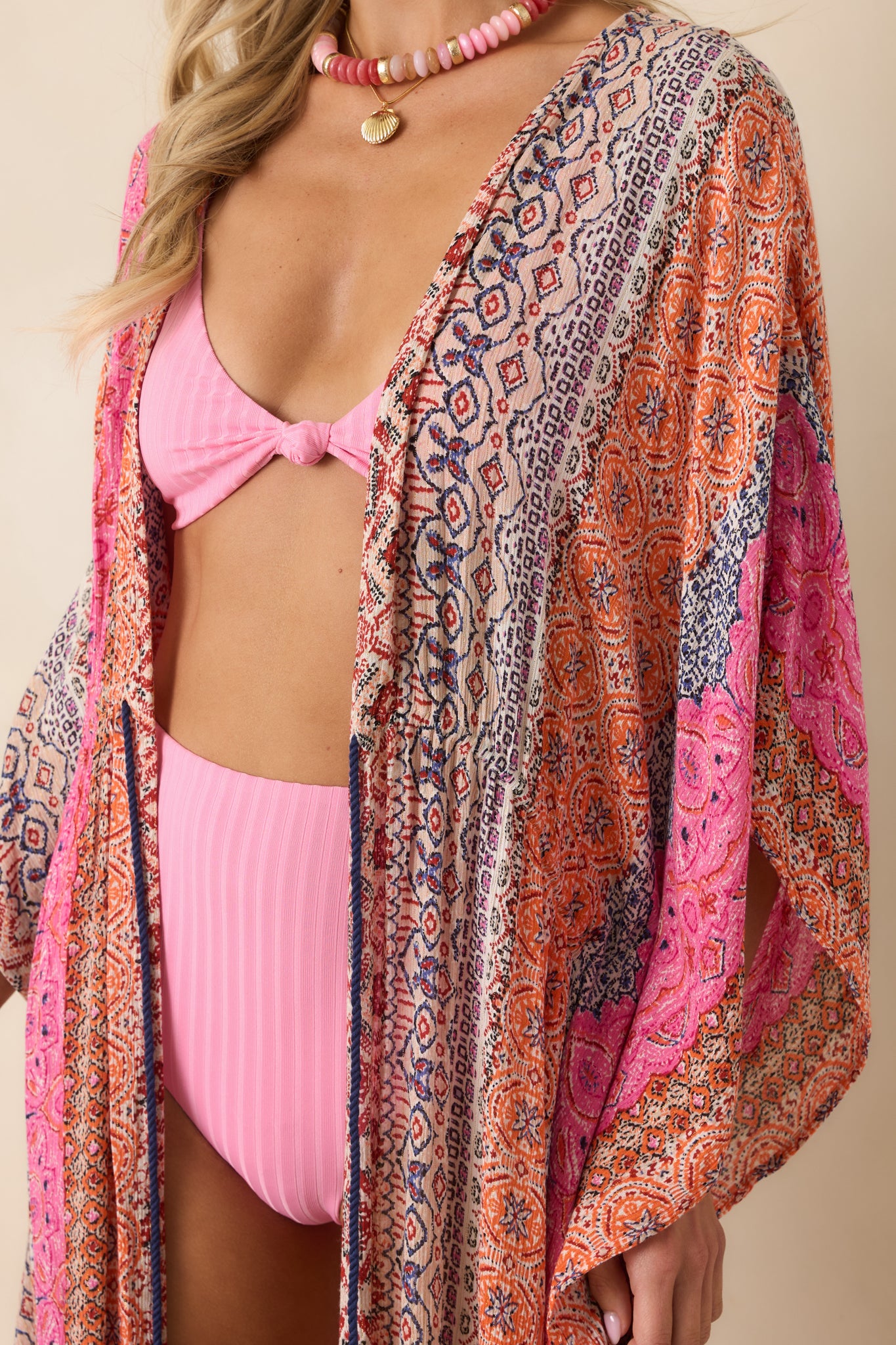 Close-up of maxi dress showing blue rope drawstring waist with fringe tassel accents and stripe print.