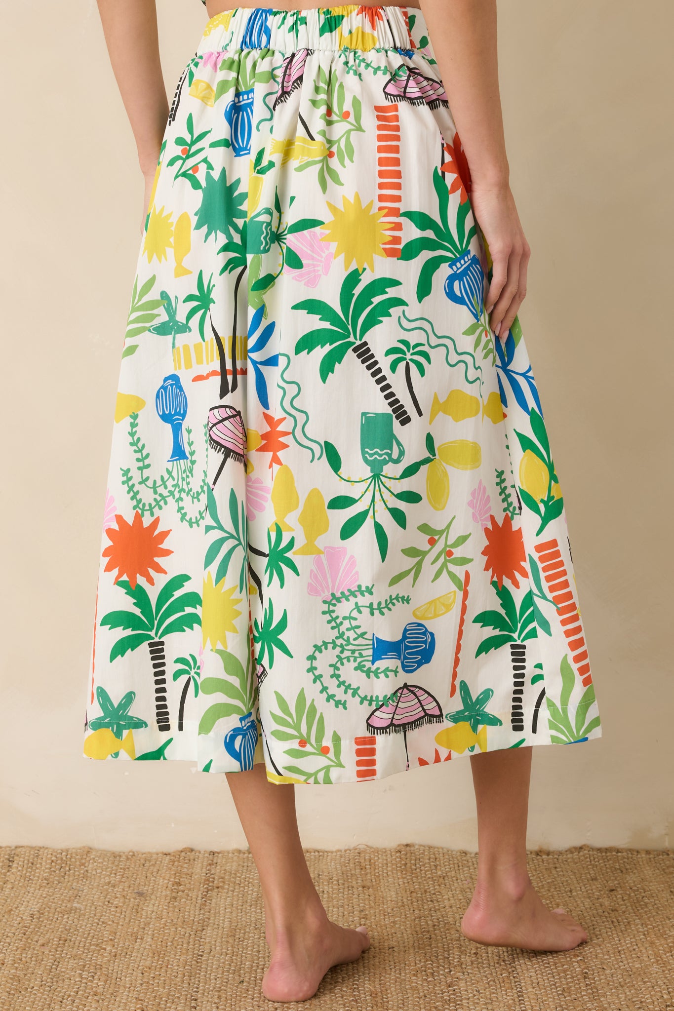 Rear view of the white multi midi skirt featuring a flowing A-line shape, lightweight cotton fabric, and vibrant allover print.