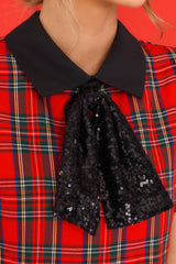Close up view of this dress that features a collar neckline with a sequin bow detail.