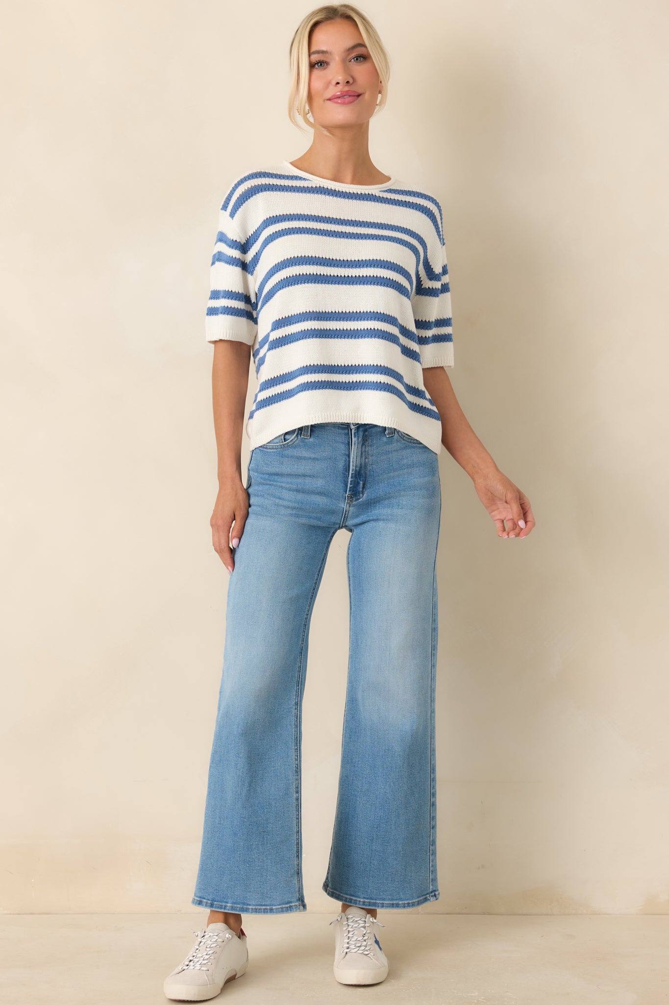 Ivory knit top with blue horizontal stripes and relaxed fit silhouette.