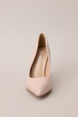 Front view of these Beige heels with a pointed toe, vibrant color, glossy finish, and skinny heel.