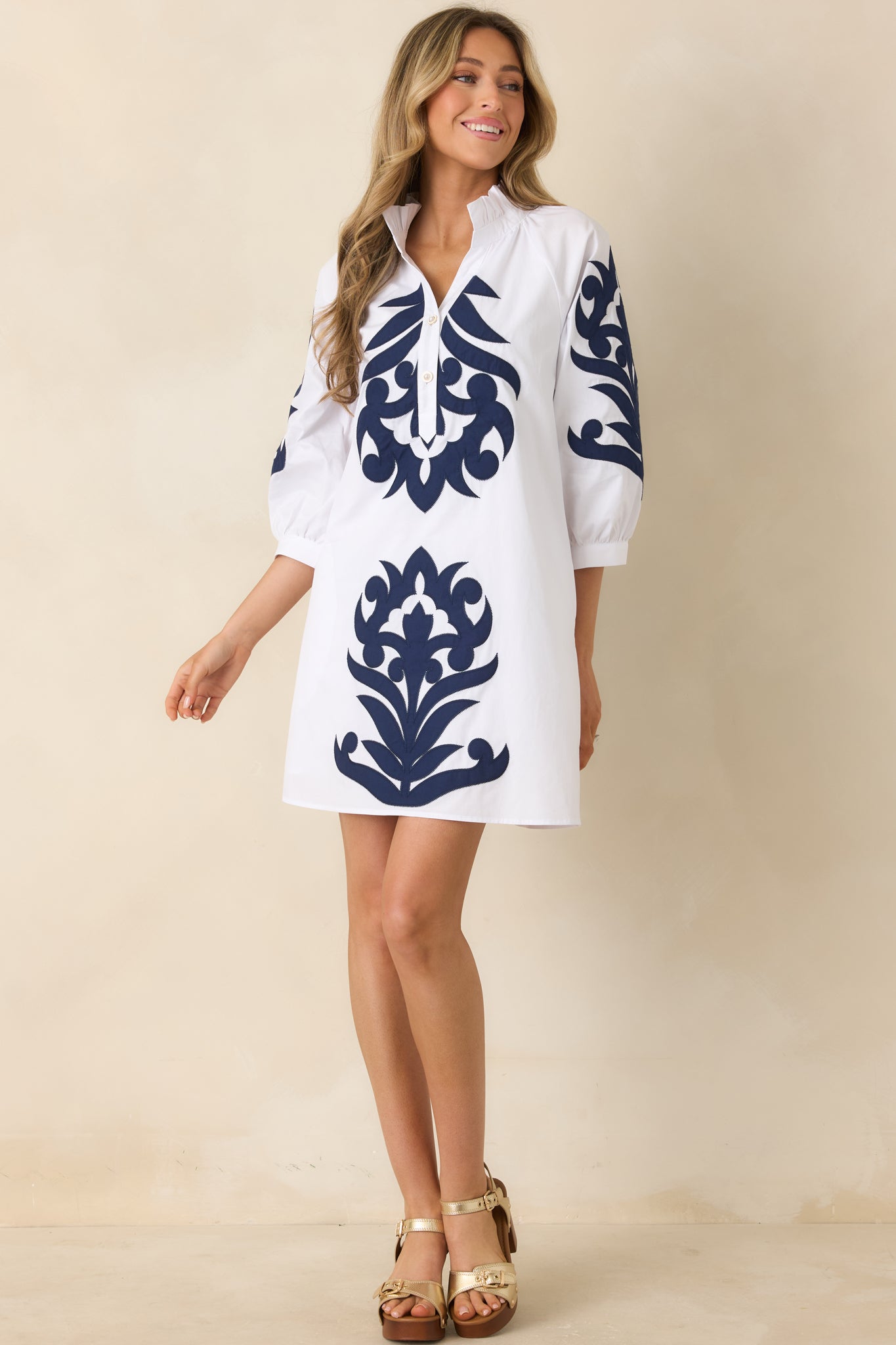White mini dress with bold navy contrast detailing and split neckline.