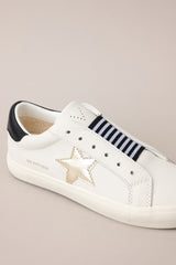 Close up view of these sneakers that feature a rounded toe, a laceless design, a comfortable fit, and a star detail.