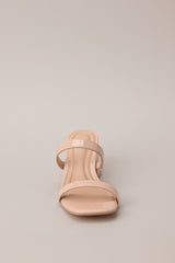 Front view of these tan block heels that feature a square toe, two nude straps across the top of the foot, and a block heel.
