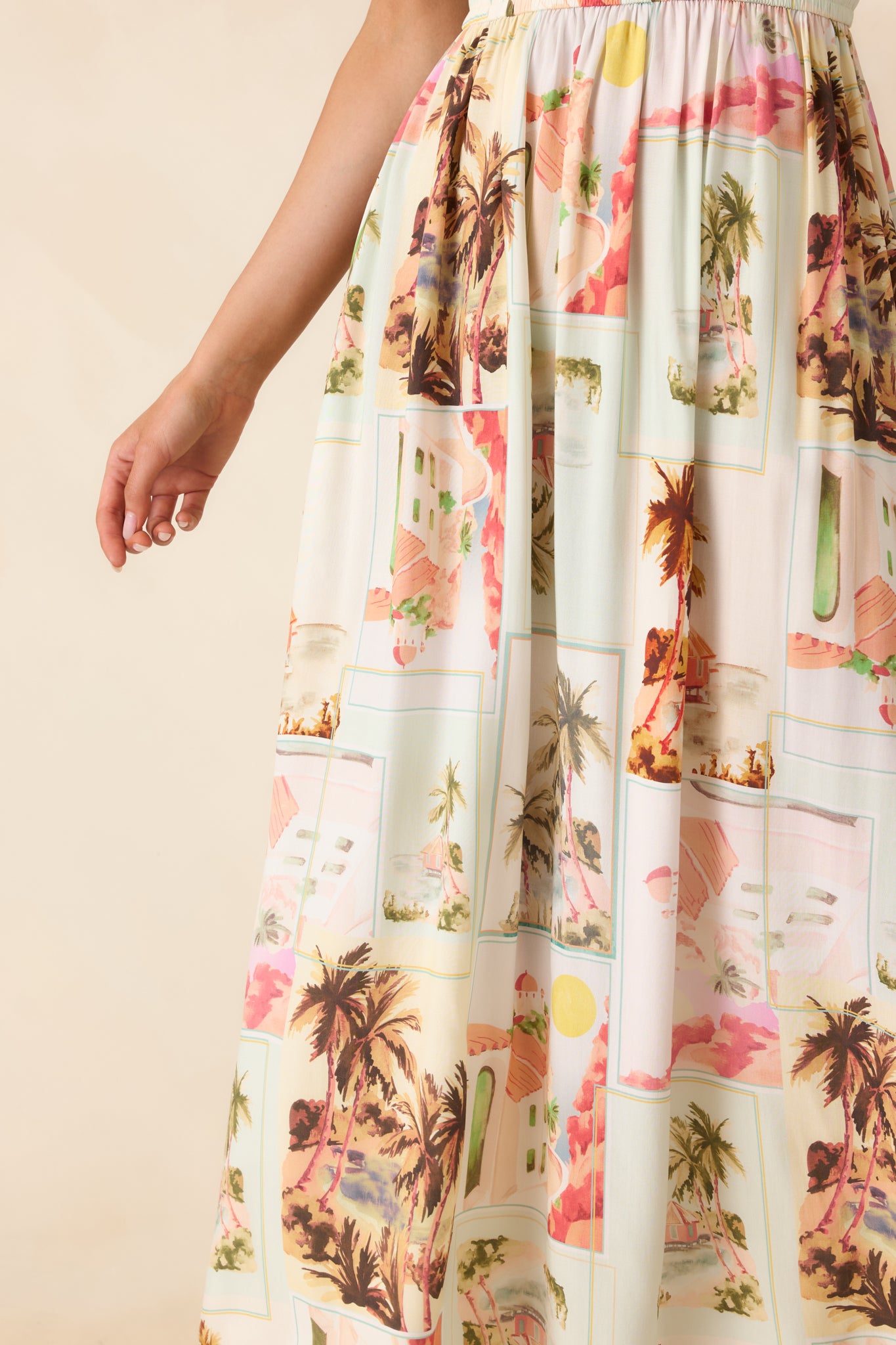 Close-up of multi postcard print fabric showing palm tree motifs, soft sun-faded tones, and smooth LENZING™ viscose texture.