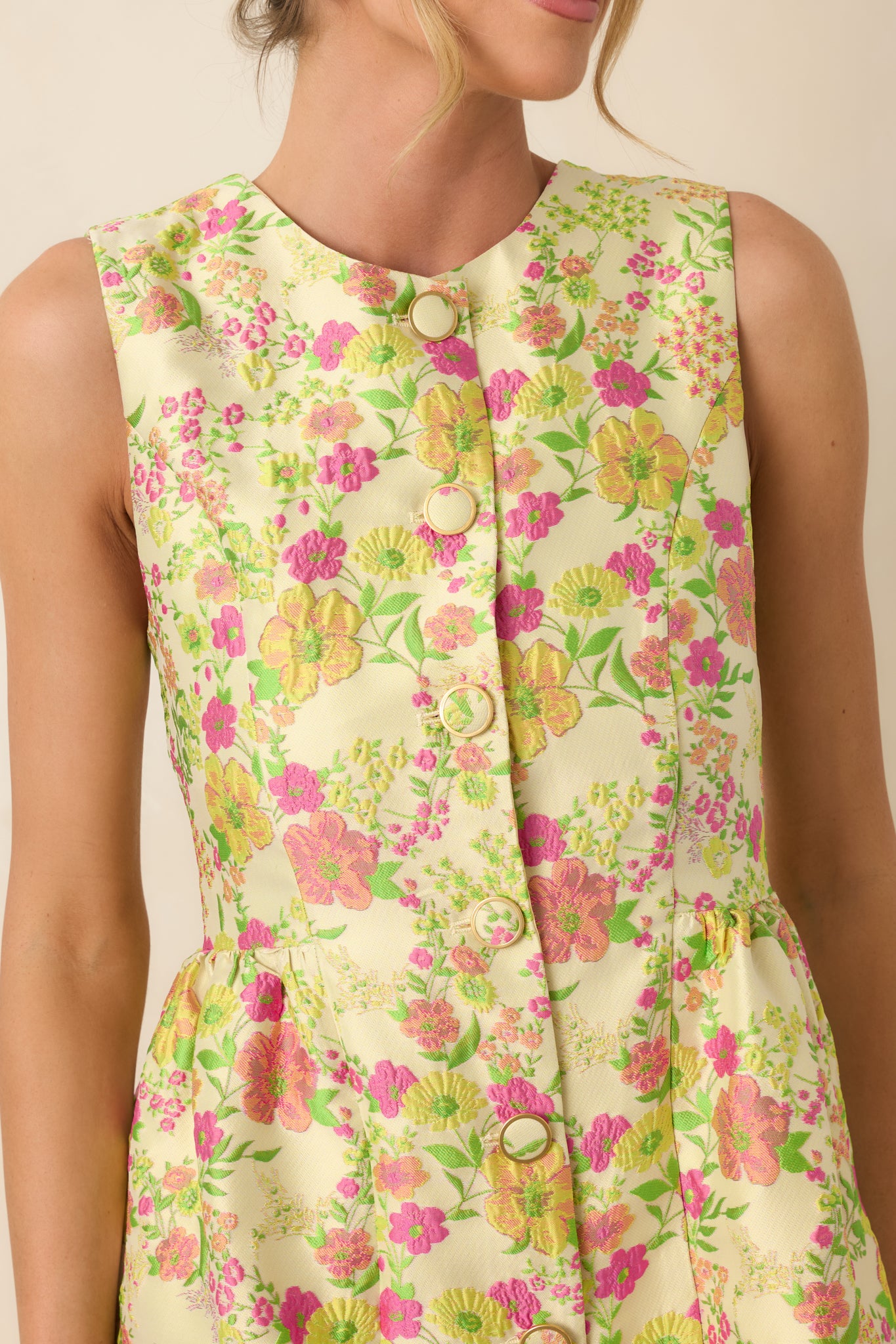 Close-up of yellow multi floral fabric with button-front detail, showcasing vibrant colors and retro-inspired print.