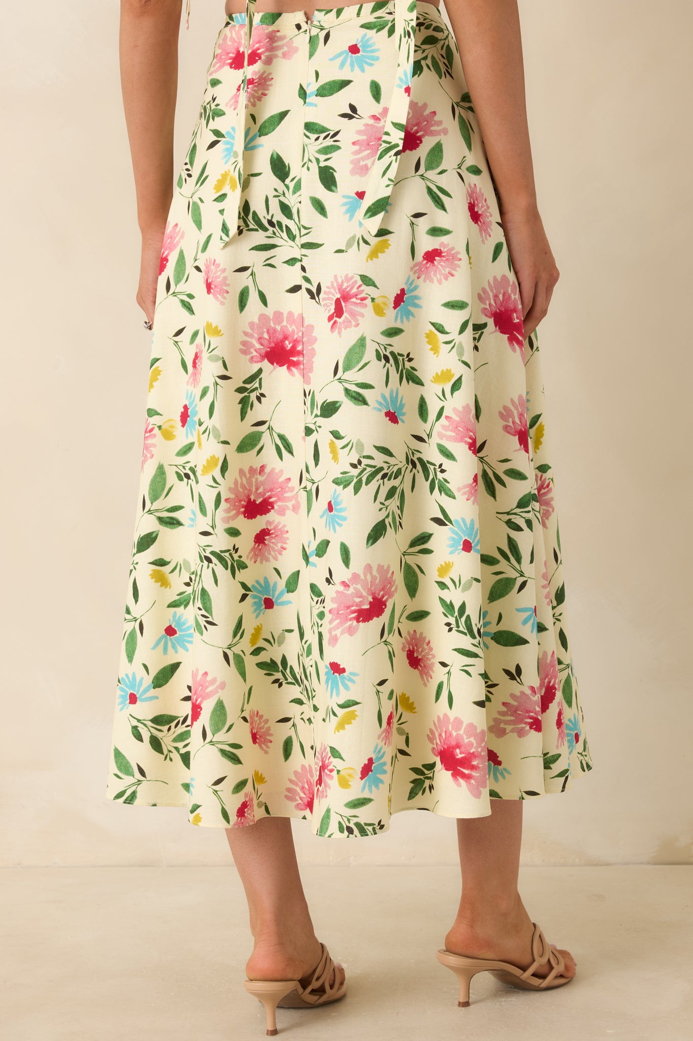 Back view of the ivory floral midi skirt featuring a high-rise waistband, flowing A-line silhouette, and continuous floral print.
