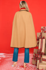 Back view of this poncho that features functional pockets, faux leather trim, and button closure.