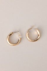 Overhead view of these earrings that feature gold hardware, a matte finish, and a functional clasp closure.