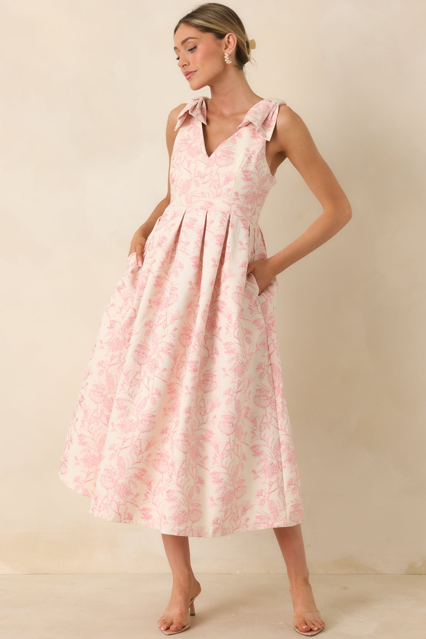 Full-length front shot of a soft pink toile-inspired floral dress with structured bodice and flowing midi skirt.