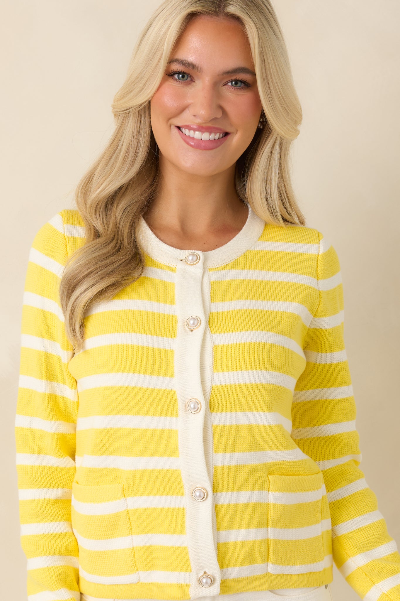 Cropped view focusing on decorative gold-tone buttons and round neckline.