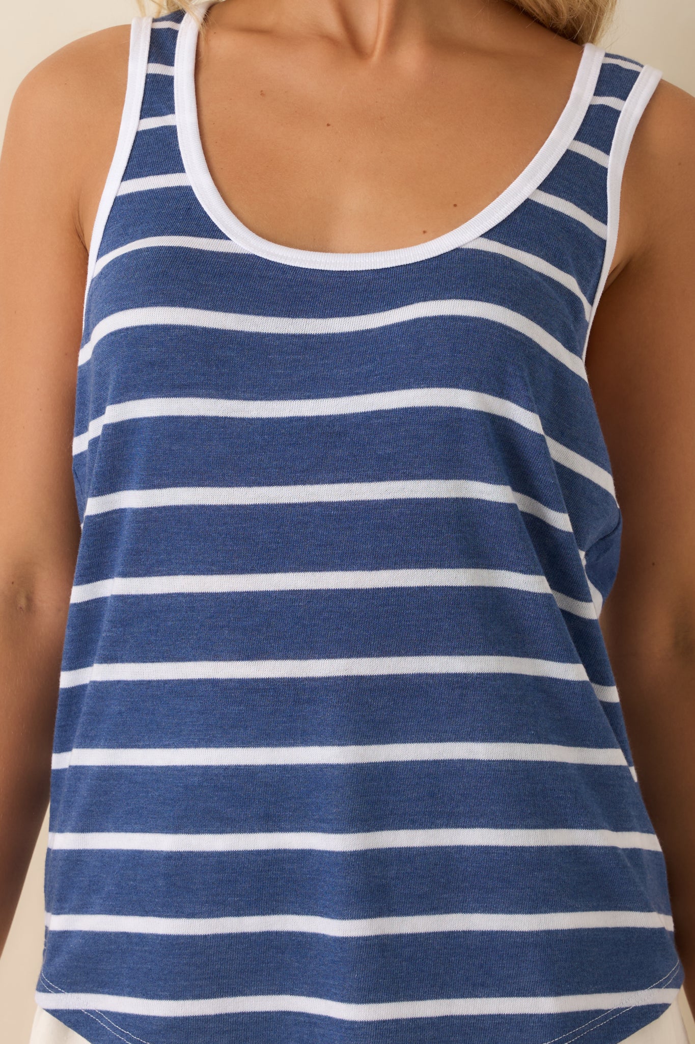 Close-up of the fabric showing the deep blue stripe pattern and crisp white trim stitching along the neckline.