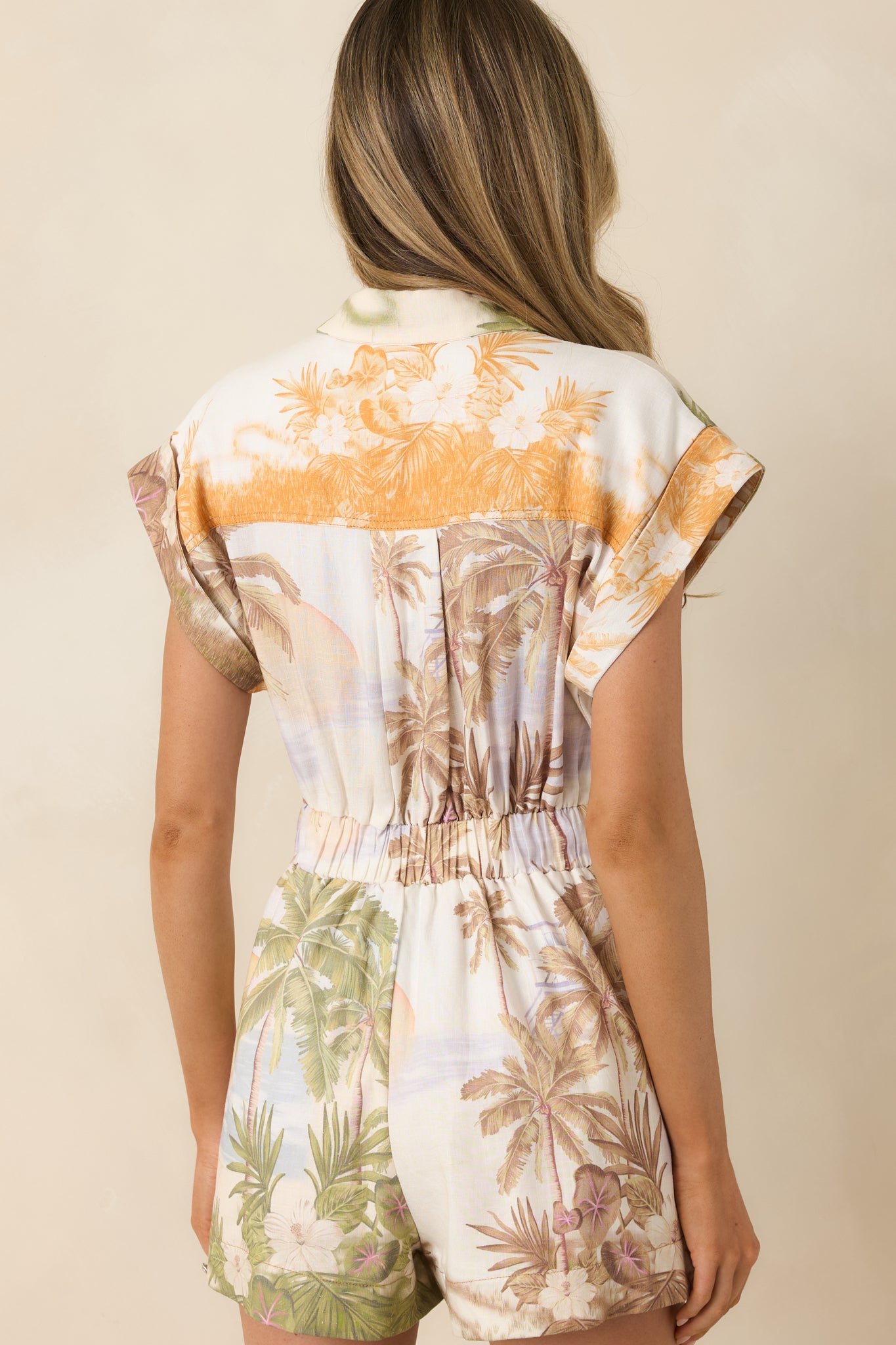 Rear view of romper with relaxed cap sleeves and adjustable waist tie.