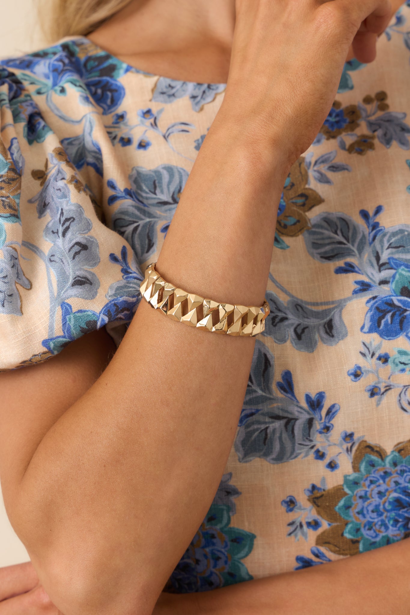 Cropped view of gold stretch bracelet featuring faceted textured links and a chunky geometric silhouette.
