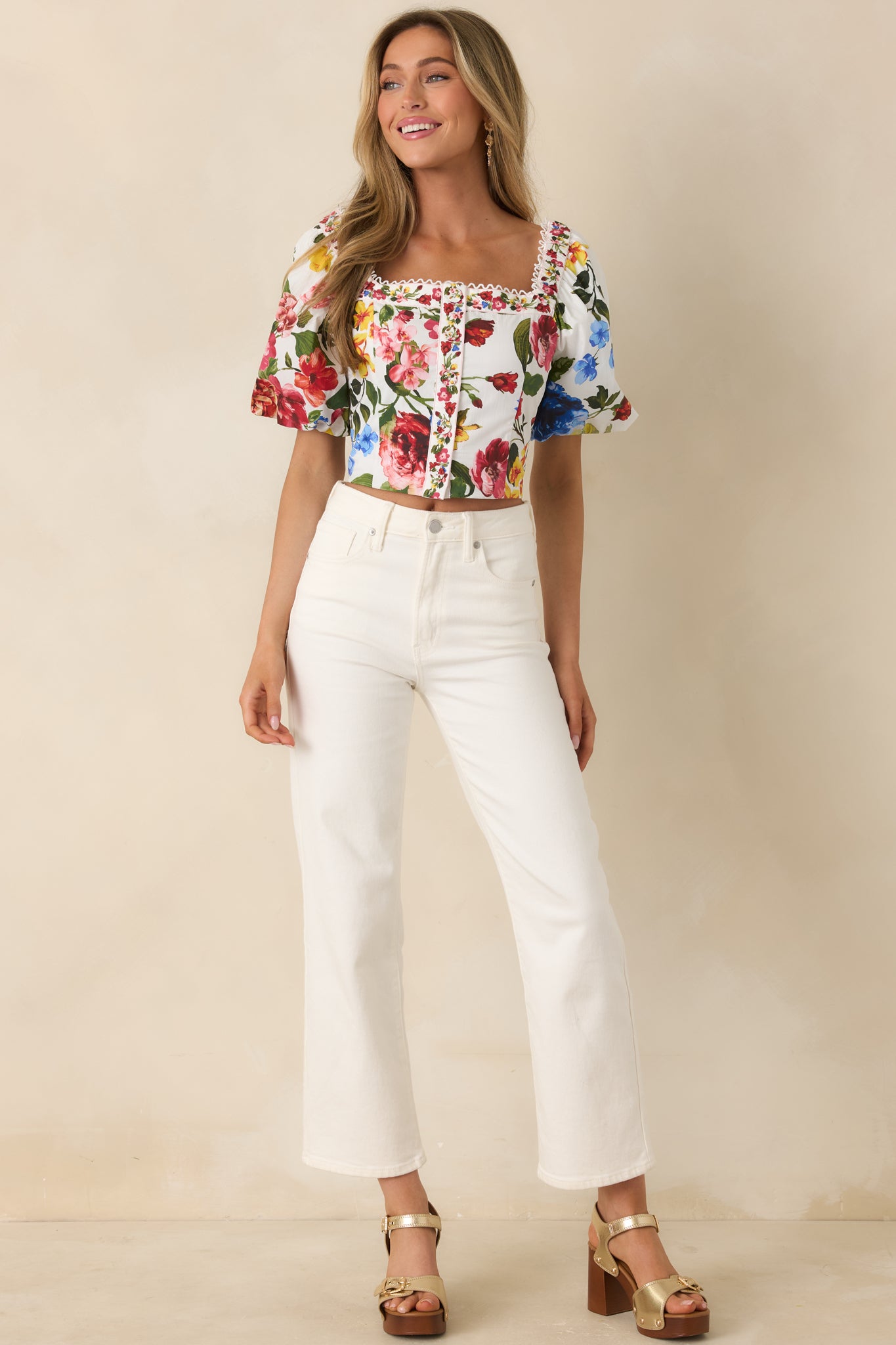 Structured ivory floral top with puff sleeves and polished fit.