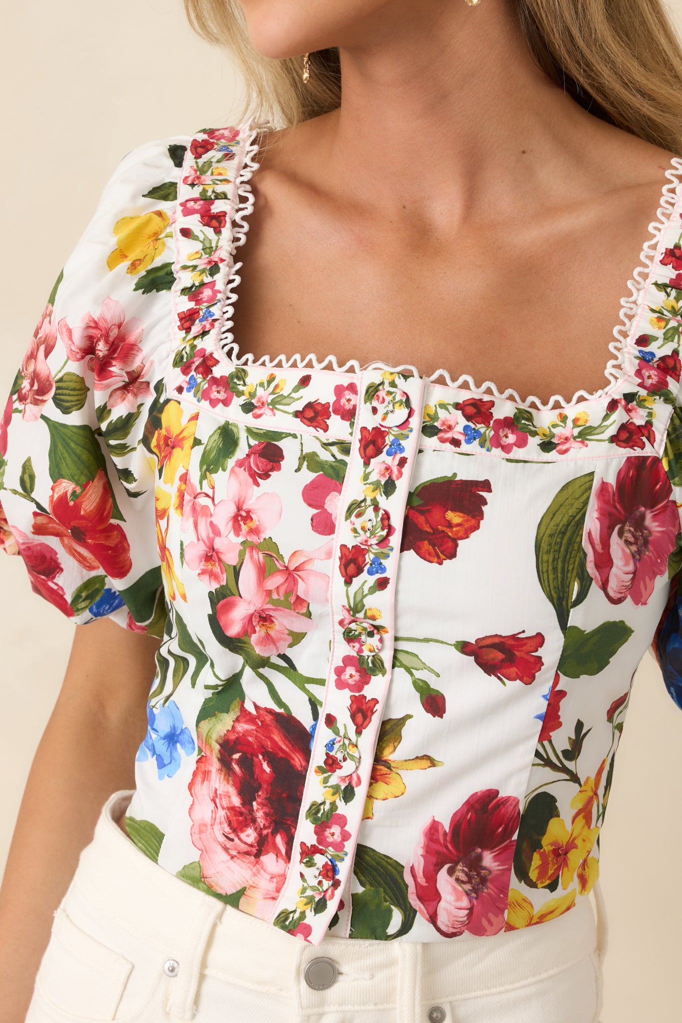 Detailed ivory fabric showing vibrant multi-floral print and border trim.