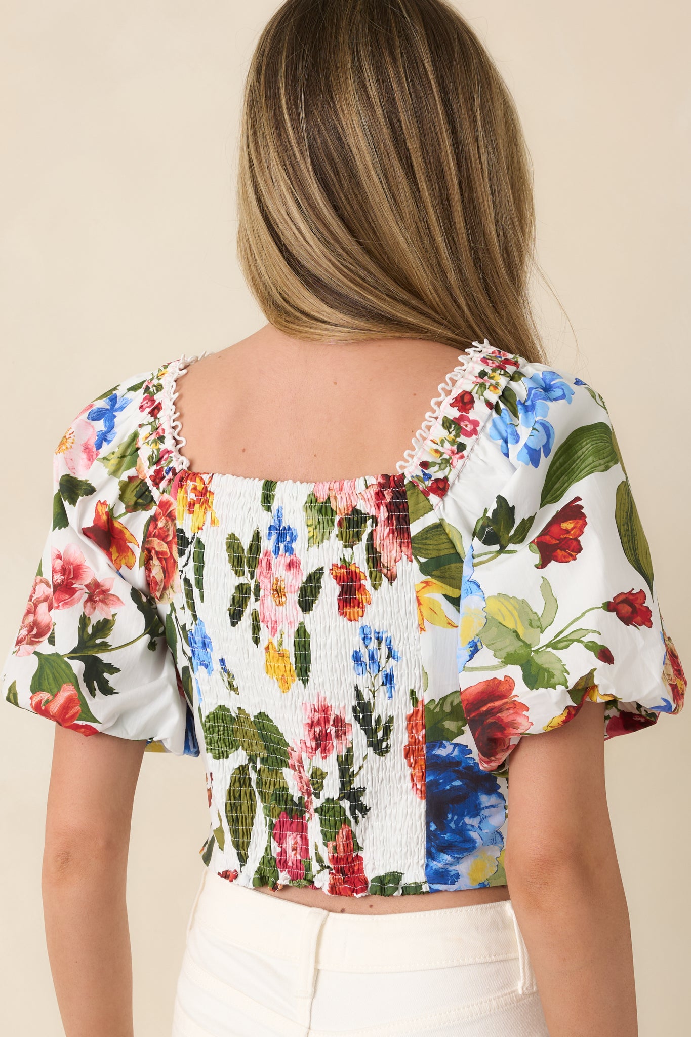 Ivory floral top with structured silhouette and puff sleeve detail from rear.