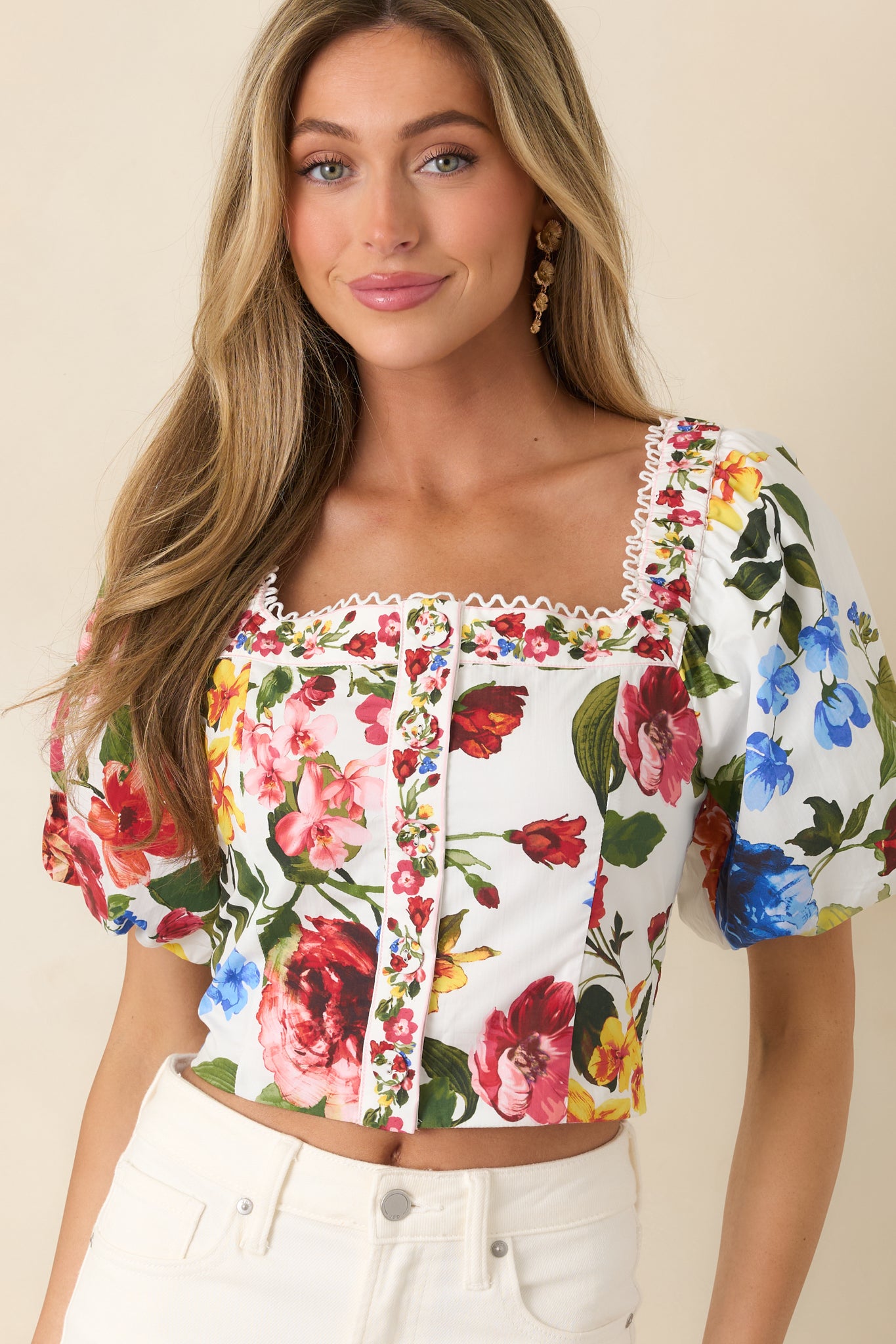 Puff sleeve detail on ivory top with intricate floral print.