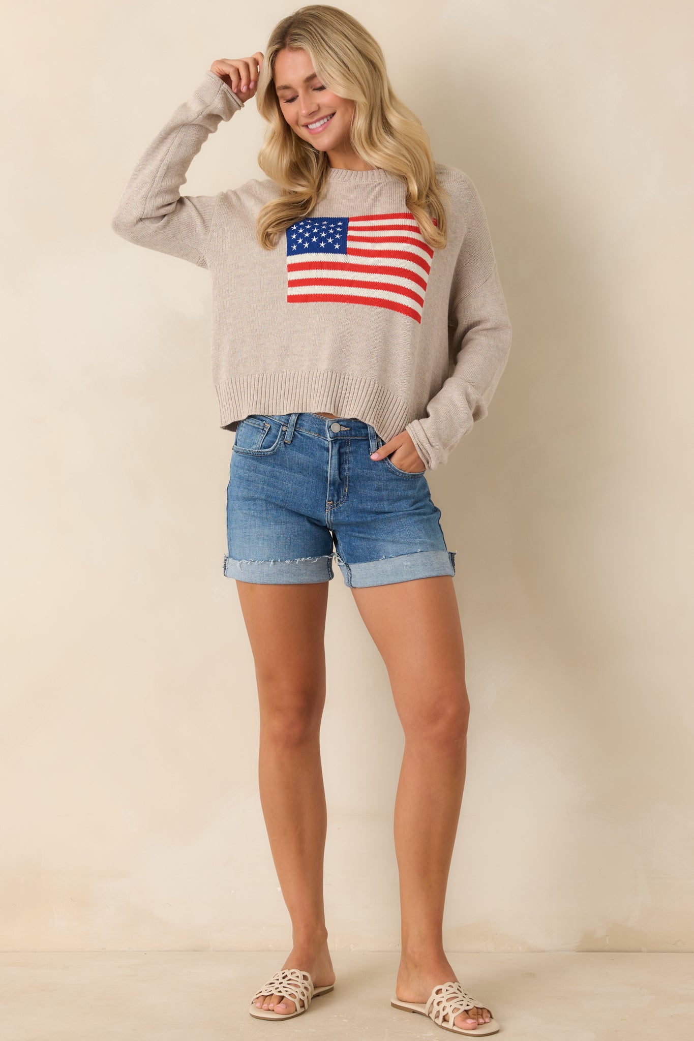 Natural heather knit sweater with soft textured fabric, relaxed long sleeve fit, and front American flag graphic.

