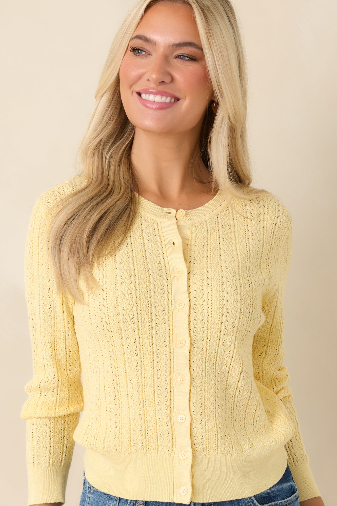 Partial view of cropped cardigan highlighting soft structure and airy fabrication.