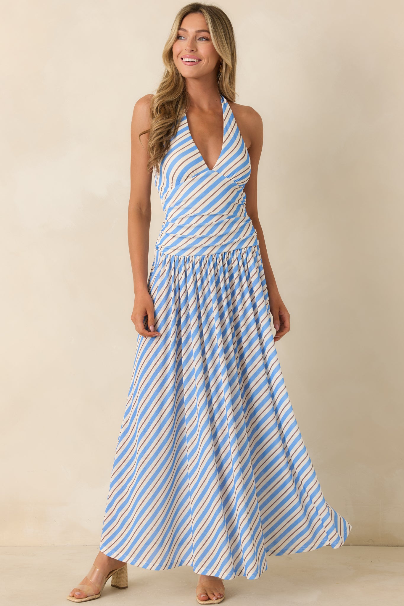 Halter maxi dress with an allover stripe print, feminine silhouette, and soft, graceful drape.
