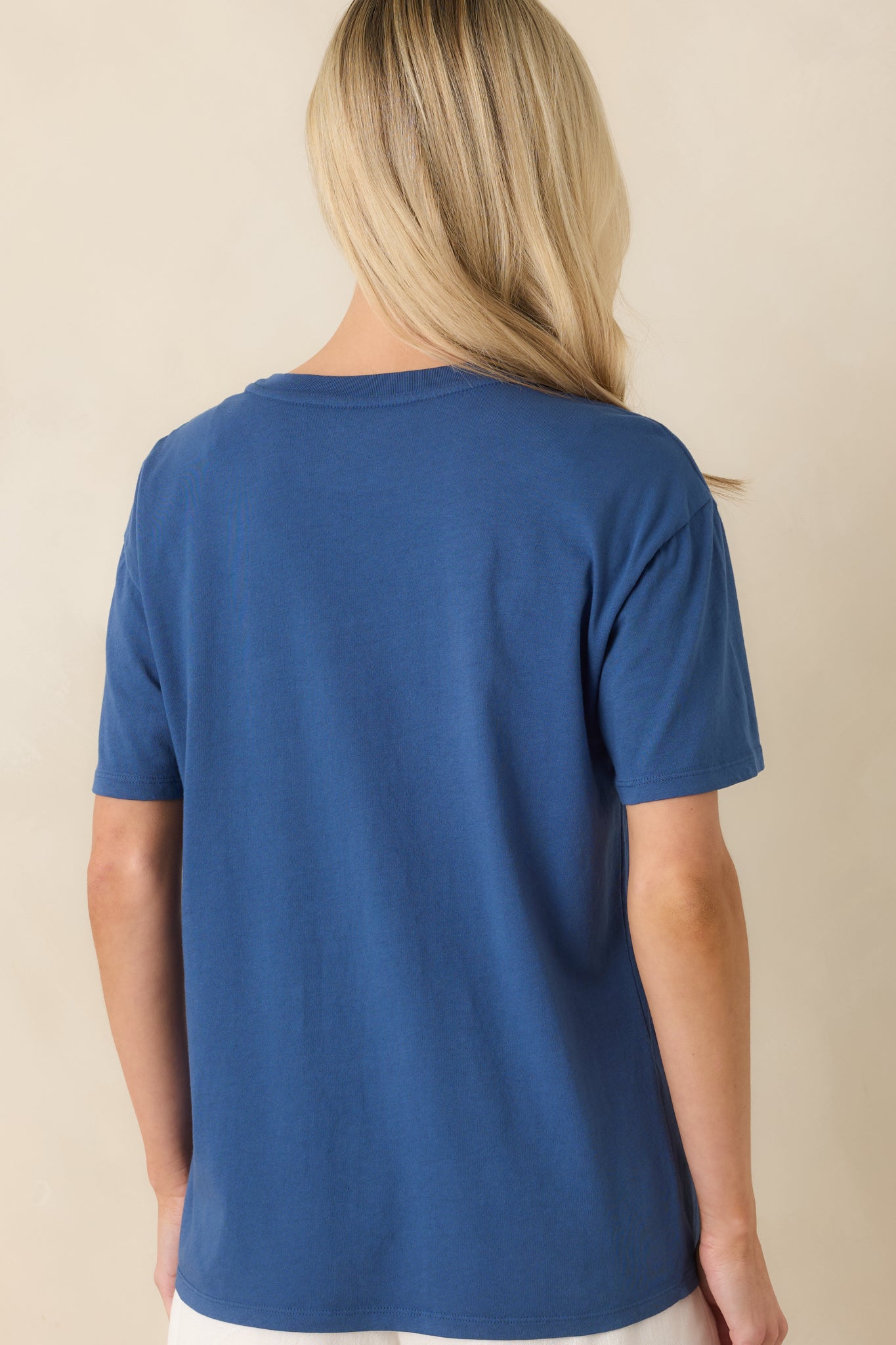 Rear view of the graphic tee featuring a clean, solid deep blue finish with relaxed boyfriend fit and classic crew neckline.

