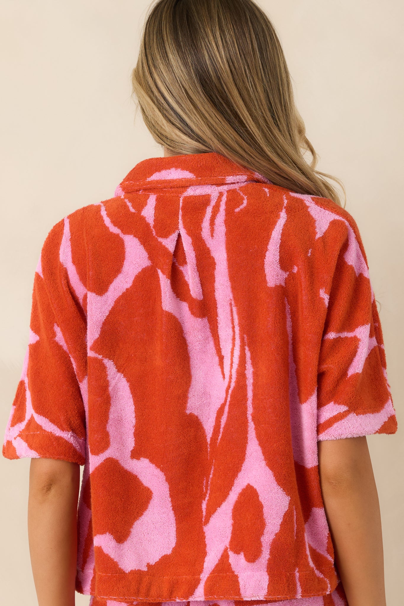 Rear view of floral shirt showing relaxed slightly cropped fit and vibrant pink and red abstract pattern.