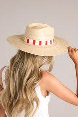 This hat features a woven striped band, and is handmade with palm fronds.