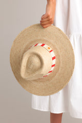 Detailed view of this hat that features a woven striped band, and is handmade with palm fronds.