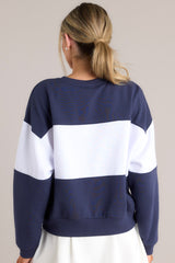 Back view of this sweatshirt that features a ribbed crew neckline, high contrast color blocking, embroidered & terry cloth wording, ribbed cuffed sleeves, and a ribbed hemline.