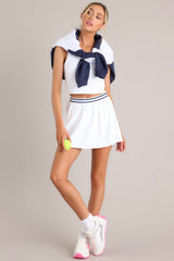 This white skirt feature a high waisted design, an elastic waistband, built-in shorts, with functional pockets, and a flowing skirt.