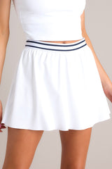 Close up view of this skirt that feature a high waisted design, an elastic waistband, built-in shorts, with functional pockets, and a flowing skirt.