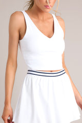 Full front view of this tank that feature a v-neckline, thin straps, a low back, a built-in shelf bra, removable padding, and a cropped hem line.