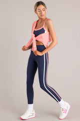 These blue leggings feature a high waisted design, thick waistband, a pocket in the back of the waistband, and colored stripes down the legs.