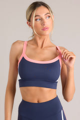 Front view of this tank bra that features a rounded neckline, thin straps, removable padding, a color block pattern, and a thick waistband.