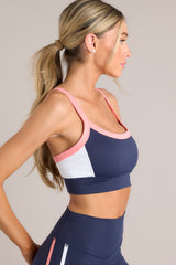 This blue, white, and pink tank bra features a rounded neckline, thin straps, removable padding, a color block pattern, and a thick waistband.