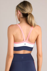 Back view of this tank bra that features a rounded neckline, thin straps, removable padding, a color block pattern, and a thick waistband.