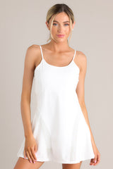 Front view of this dress that features a rounded neckline, thin adjustable straps, a built-in shelf bra, built-in shorts with functional pockets, and semi transparent detailing.