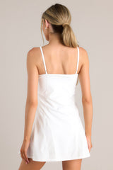 Back view of this dress that features a rounded neckline, thin adjustable straps, a built-in shelf bra, built-in shorts with functional pockets, and semi transparent detailing.
