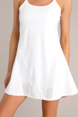Close up view of this dress that features a rounded neckline, thin adjustable straps, a built-in shelf bra, built-in shorts with functional pockets, and semi transparent detailing.