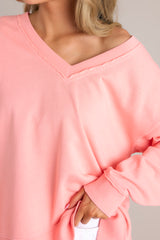 Close up view of this sweatshirt that features a v-neckline, a soft material, a split hemline, and ribbed cuffed sleeves.