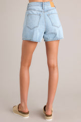 Back view of these denim shorts that feature a high waist, classic button-zipper closure, functional belt loops, and five pockets.