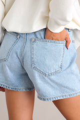 Close up back view of these denim shorts that feature a high waist, classic button-zipper closure, functional belt loops, and five pockets.