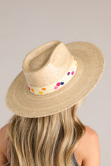 Full view of this hat that features a cotton woven band with multicolor polka dots, and is handmade with palm fronds.
