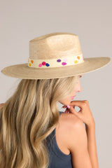 This hat features a cotton woven band with multicolor polka dots, and is handmade with palm fronds.