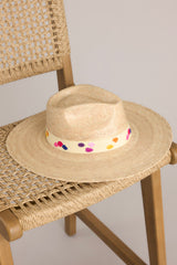 Detailed view of this hat that features a cotton woven band with multicolor polka dots, and is handmade with palm fronds.