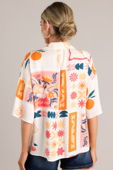 Back view of this apricot multi print top that features functional buttons down the front, a citrus and floral print design, a collared neckline, and lightweight fabric.