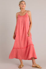 This coral midi dress features a gauze cotton fabric, adjustable straps, and a tiered skirt.