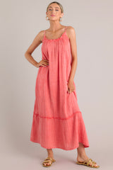 Full body view view of this coral midi dress that features a gauze cotton fabric, adjustable straps, and a tiered skirt.