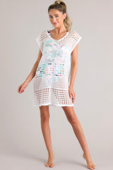 This white cover up features an open knit crochet design, short cap sleeves, and a lightweight breathable fabric.